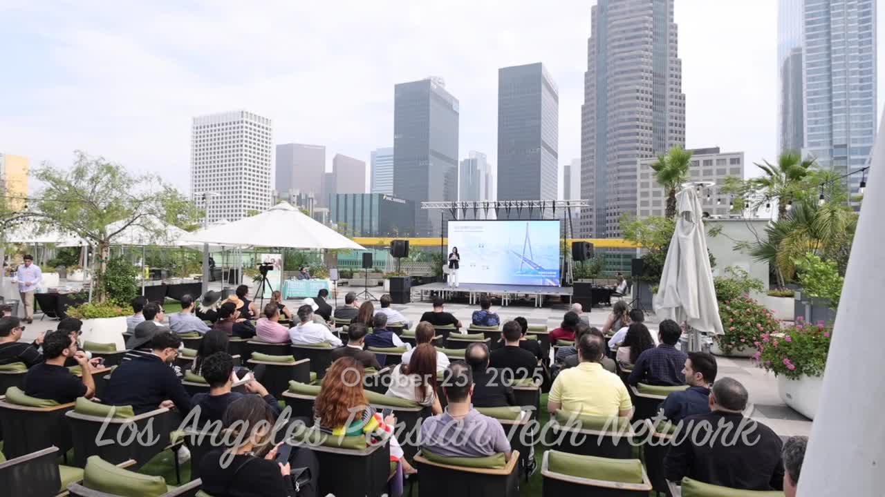 A full rooftop audience at a Persian Tech Network event with the Los Angeles skyline behind the stage